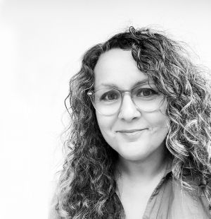 Auf dem schwarz-weißen Foto lächelt Rehana Ali den Betrachter an. Sie ist Texterin und Konzeptionerin von emotionalen Werbekampagnen bei diekommunikatiefe Werbeagentur. 