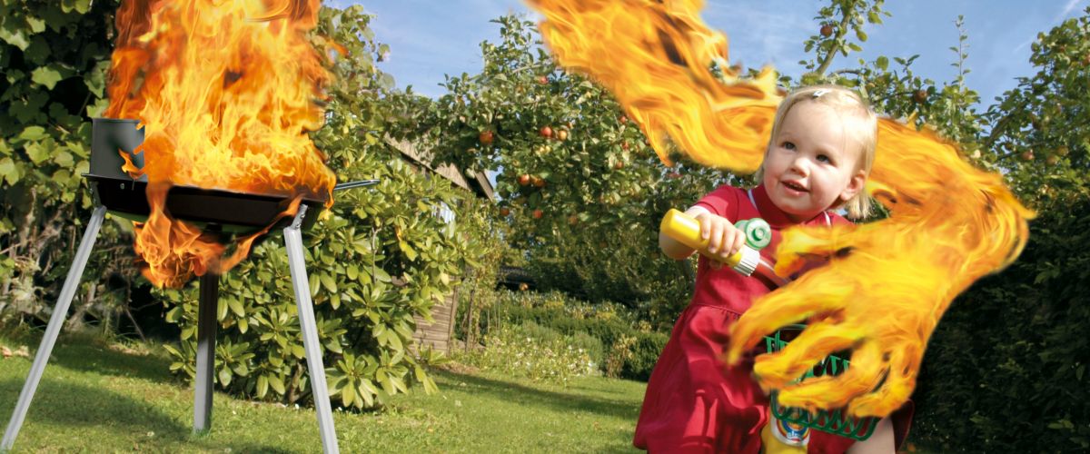 Kampagnenmotiv der Paulinchen Grillkampagne mit Kind auf Dreirad, Grill und Flammen